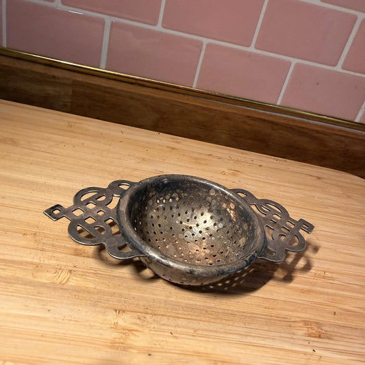 Vintage silver plated tea strainer with decorative handles